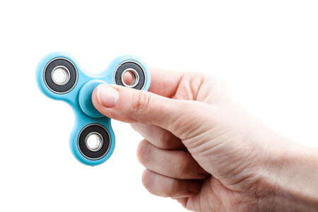 Hand holding popular fidget spinner toy isolated on white background.の写真素材