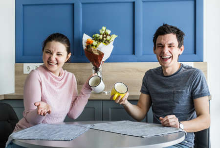 Romantic couple. Beautiful young loving couple having fun while drinking coffee at home.の写真素材