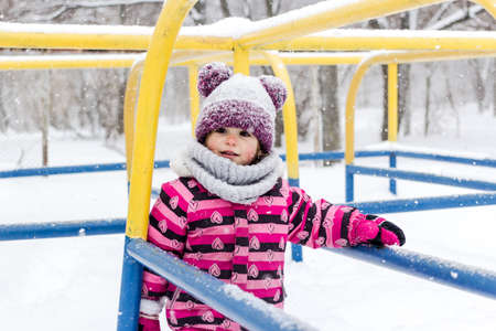 Little girl having fun outside at winter time.の写真素材
