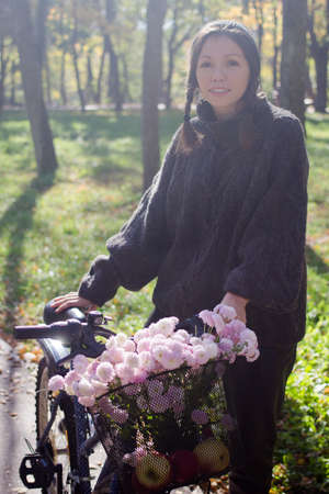 Happy young woman with bicycle relaxing in the park.の写真素材