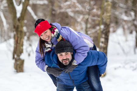 Happy young couple having fun in winter park. Family outdoor winter concept.の写真素材