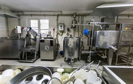 Cheese making machine in modern dairy manufactory. Factory with milk pasteurization tank and pipes