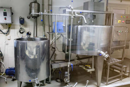Cheese making machine in modern dairy manufactory. Factory with milk pasteurization tank and pipes