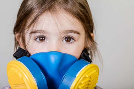 Little girl has special defence mask protect herself from Coronavirus COVID-19, child with a mask on her nose for safety outdoor activity, illness or air pollutionの写真素材