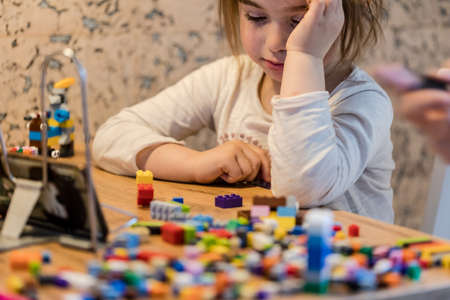 Covid-19 Coronavirus and Learning from home. Little girl online learning and creating at home....