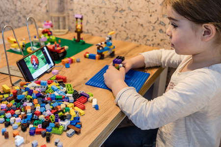 Covid-19 Coronavirus and Learning from home. Little girl online learning and creating at home. Quarantine and Social distancing concept.の写真素材