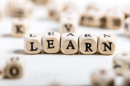 Word LEARN formed by wood alphabet blocks. On old wooden table.の写真素材