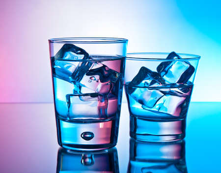 Two cocktails on the rocks on a reflective surfaceの写真素材