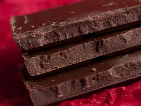 Three pieces of chocolate on red backgroundの写真素材