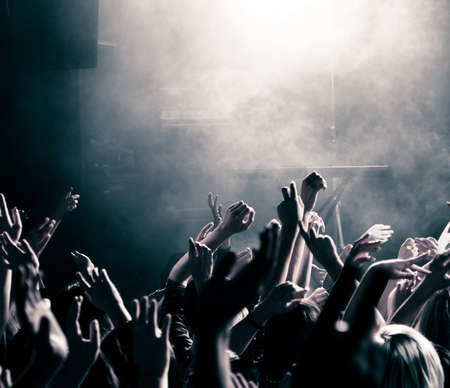 Concert crowd with hands up, toned