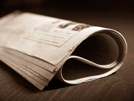 Rolled newspaper on the tableの写真素材