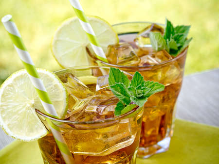 Refreshing peach, lime and mint ice tea served outdoorsの写真素材