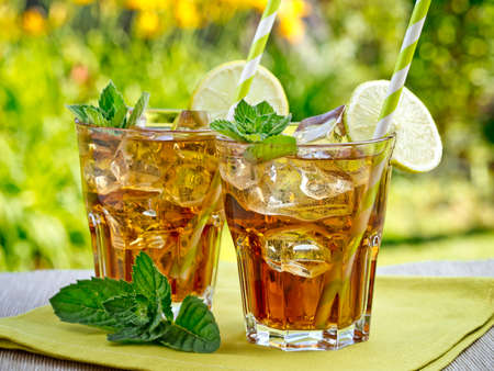 Refreshing peach, lime and mint ice tea served outdoorsの写真素材