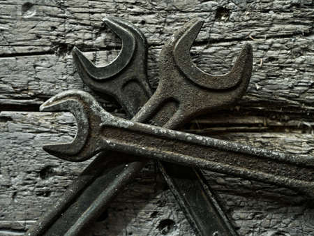 Old wrenches on a wooden background