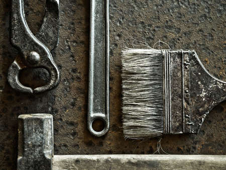 Hammer, brush, pincers and wrench over rusty metal background