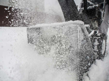 Snowblower at work on a winter day with a lot of snow