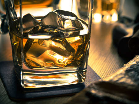One glass of whiskey on the rocks on a wooden tableの写真素材