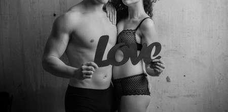 Passionate heterosexual couple holding a love signの写真素材