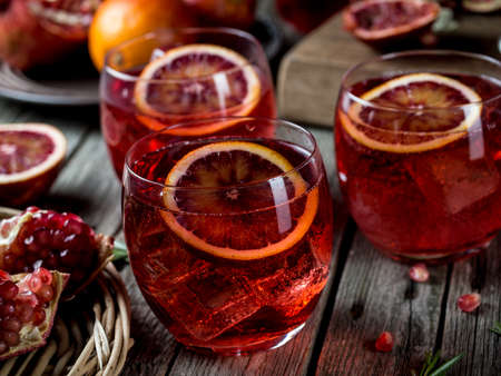 Blood orange and pomegranate cocktails on a grunge wooden tableの写真素材