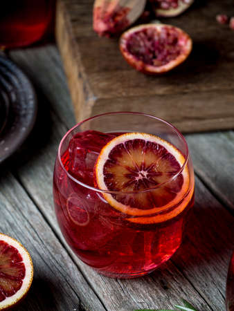Blood orange and pomegranate cocktails on a grunge wooden table