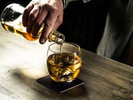Businessman pouring whiskey in his glassの写真素材