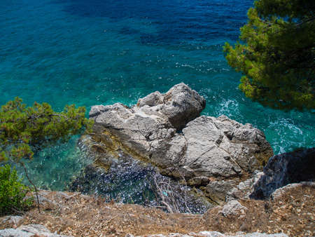 Blue and azure sea waters and rocky cliff