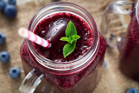Berries smoothies in glass with blueberries and mintの写真素材