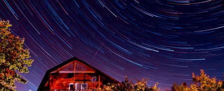 Star tracks , house, night sky background. Light