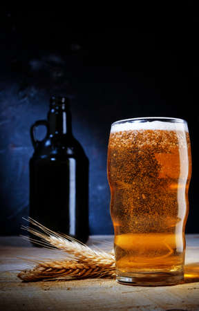 close up of beer in glass with barley on on dark background .の写真素材