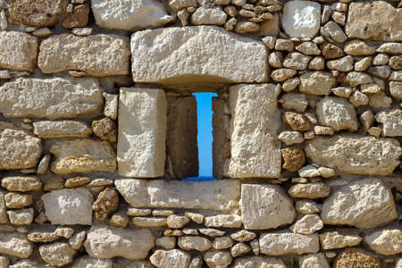 Sea over the window opening in the fortress in Greece, Heraklion. Bright sunny day outside the...
