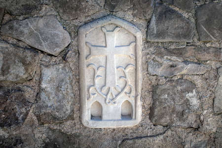 Stone cross on the wall of the Armenian Church, carved in stone with patterns and floral elementsの写真素材