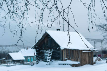 Fabulous winter landscape in a village in the north of Russia - a bright sun, white snow, cozy wooden housesの写真素材