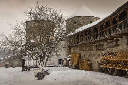 The wall of the tower and parts of red-brick castle-fortress in the city of Kamyanets-Podolsky in western Ukraine, winterのeditorial素材
