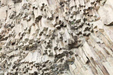 The complicated structure of volcanic rock at Cape Fiolent in Crimea. Rocks split off and forming tube. Complex texture of stoneの写真素材