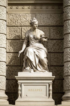 Sculpture depicting a woman in a cape with an easel in one hand and a brush in the other. Located near one of the historic houses in Vienna, Austriaの写真素材