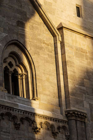 Element of architectural decoration of the Catholic Church of St. Stephen in the heart of Vienna in Austria under the setting sun. Part of wall and windowの写真素材