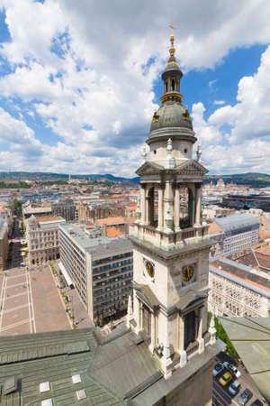 Sunny day view of the city of Budapest from the tower of the cathedral. City under blue cloudy sky with a tower in the foregroundの写真素材