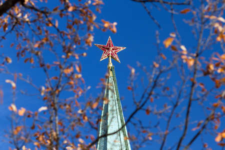 Green roof of tower of the Moscow Kremlin with red star of autumn sunny day next to a treeの写真素材