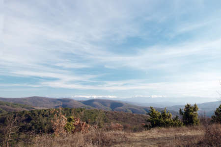 Brown autumn field in the Crimea on the background of the snow-covered mountain ranges of the peninsula under the blue skyの写真素材