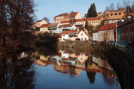 Cesky Krumlov - the famous Czech city, part of the World Heritage, UNESCO. The red roofs of the city and the tower on the background of bright blue skyの写真素材