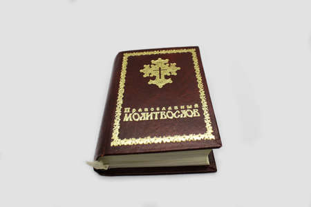 The image of a religious book on a light background. The inscription on the book Orthodox prayer...