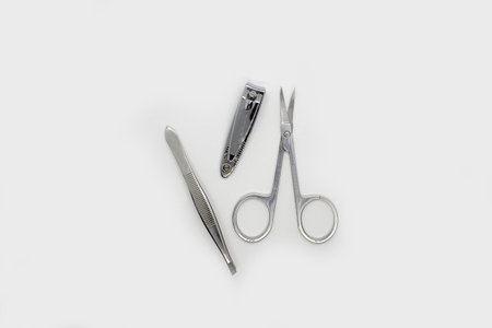 Manicure on a white background. Manicure scissors, eyebrow tweezers and nail clippers.