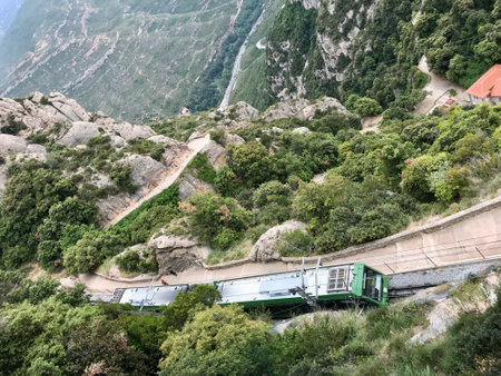 Montserrat, Spain, June 2019 - A train traveling down train tracks near a mountain. High quality photoの写真素材