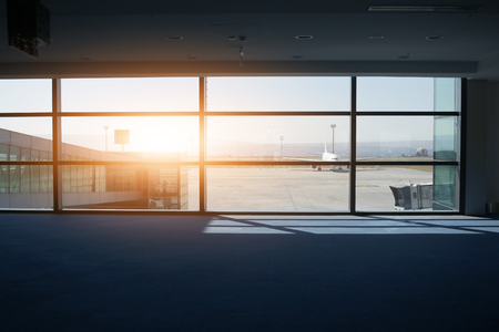 empty airport terminal and an airplane in the windowの写真素材