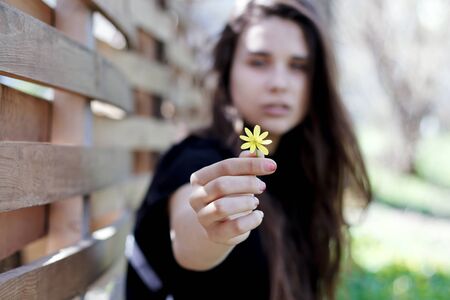 girl`s hand with a flower in focusの写真素材