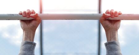 hands of a strong man holding up on the bar sport backgroundの写真素材