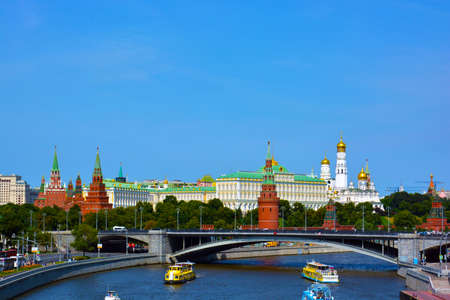 Moscow Kremlin in summer. Moscow river with pleasure boats and barges near by Kremlin.