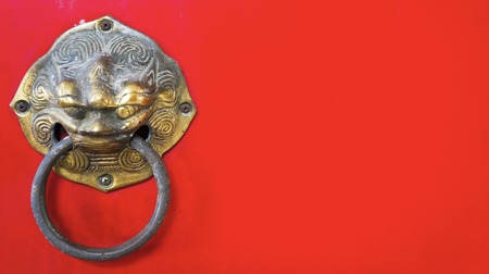 Red wooden door decorated with a lion head as a knockerの写真素材