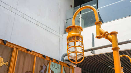 Yellow vintage metal cap lamp hanging from lamp post. (Retro style)の写真素材