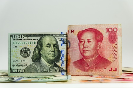 US dollar bill and China yuan banknote . America is debtor of China and now China get balance of trade with USA. so USA will increase tax for goods from China.の写真素材
